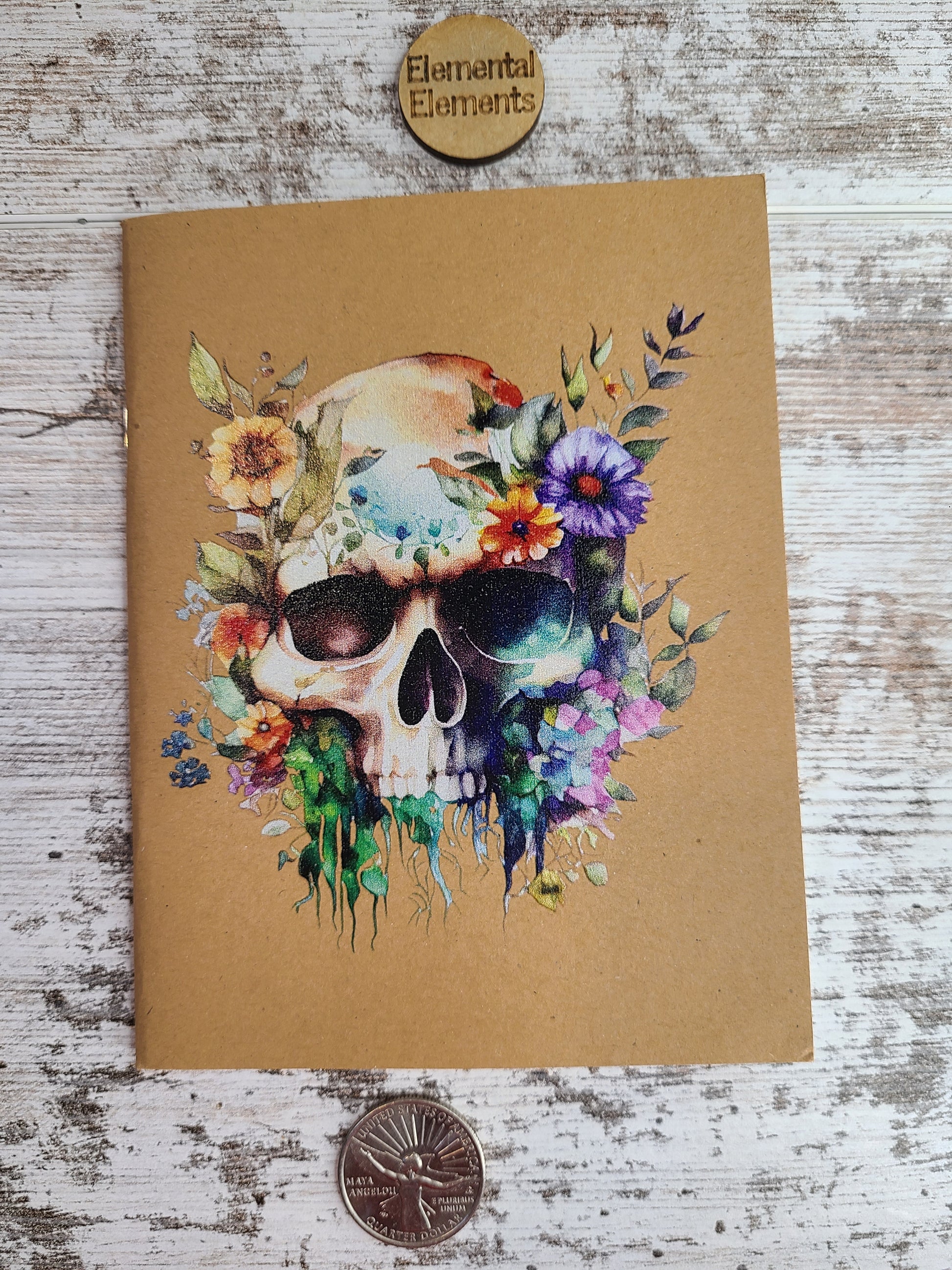 Journal with a colorful watercolor jawless skull and flowers.