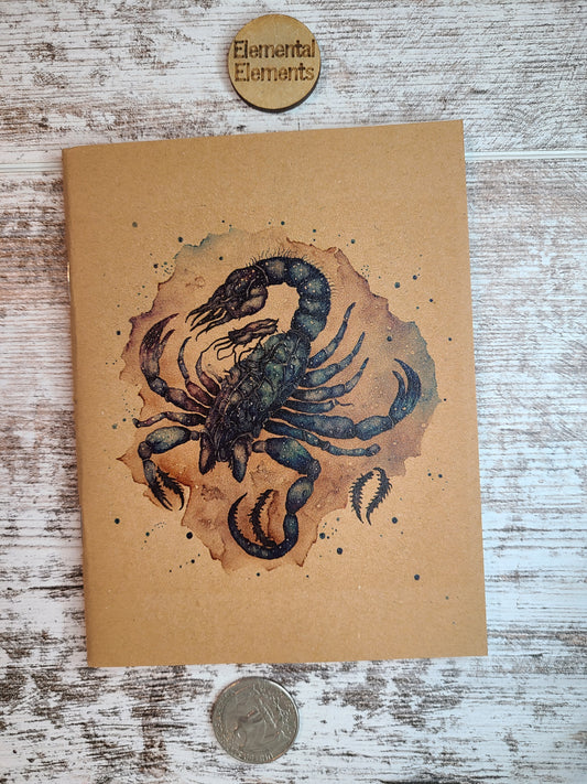 Scorpio zodiac journal green, blue, and brown scorpion with brown and teal watercolor splash background.
