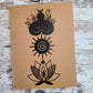 Elemental Elements journal notebook with a goddess figure, spiral sun, and lotus flower vertically top to bottom.