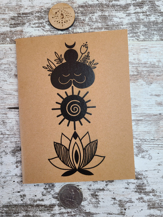 Elemental Elements journal notebook with a goddess figure, spiral sun, and lotus flower vertically top to bottom.