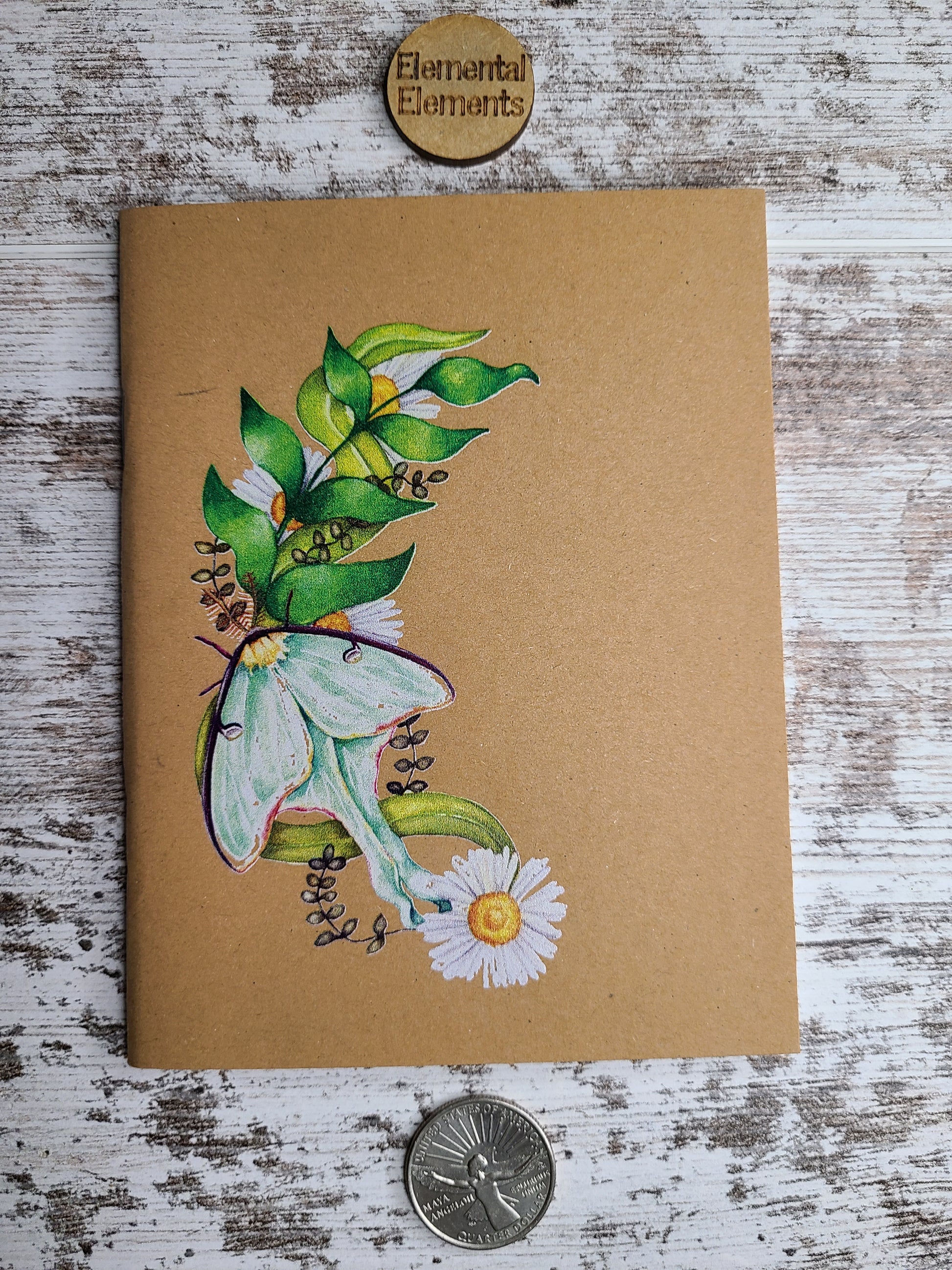 Elemental Elements journal notebook Luna Moth on a crescent moon made of leaves and daisies.