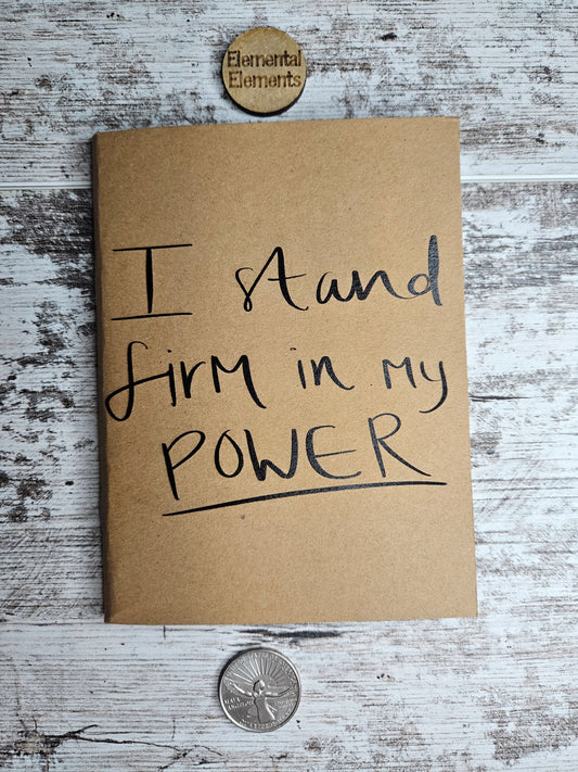 Journal with black text that says I stand firm in my power.