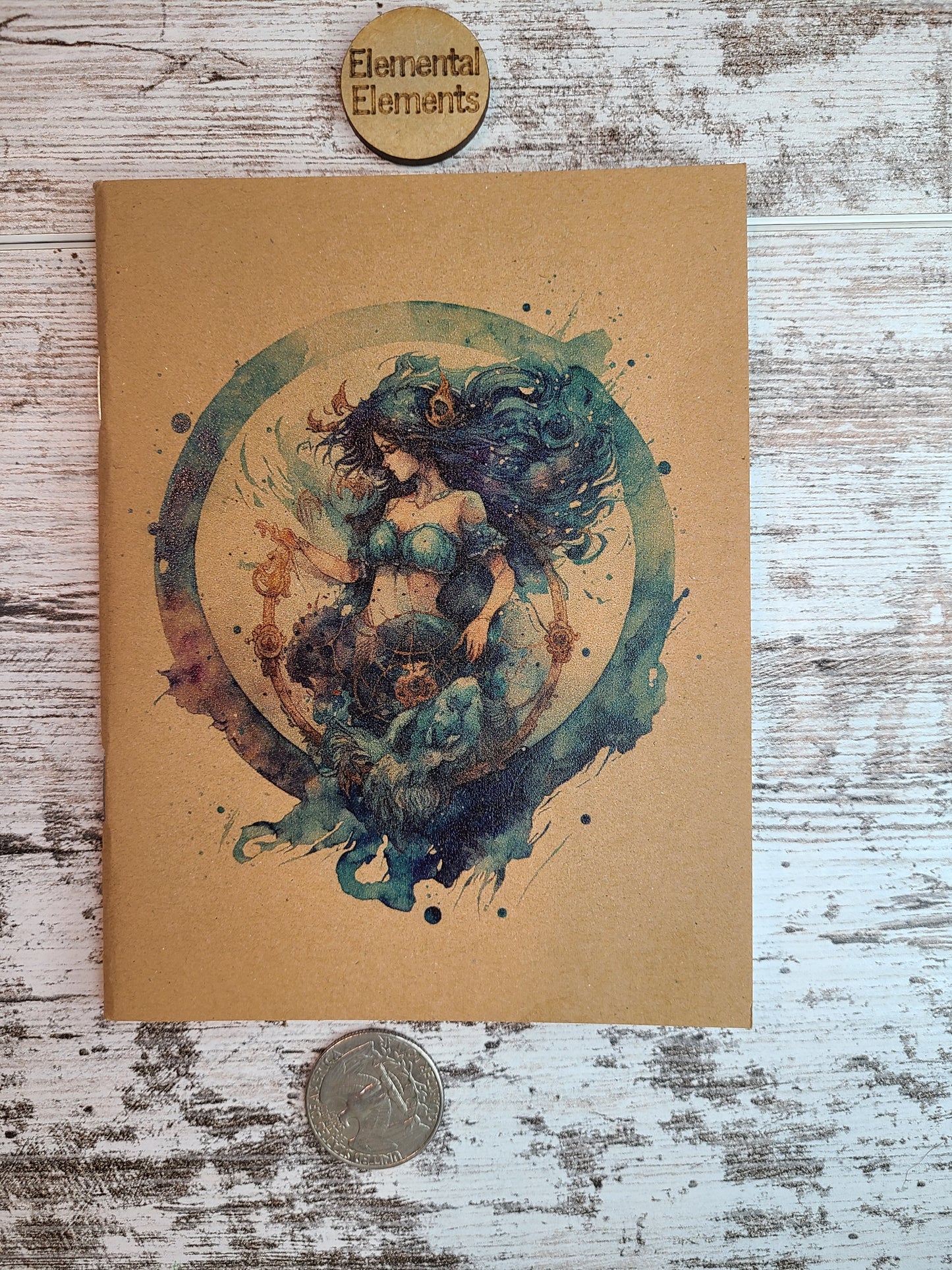 Aquarius zodiac astrology is a human with dark blue and green long flowing hair, blue two-piece clothing, gold accessories in their hair and bottoms. There is a gold detailed u-shaped piece below Aquarius that Aquarius is holding and looking down at, and it is all within a watercolor circle made up of blues, greens, and purple.  