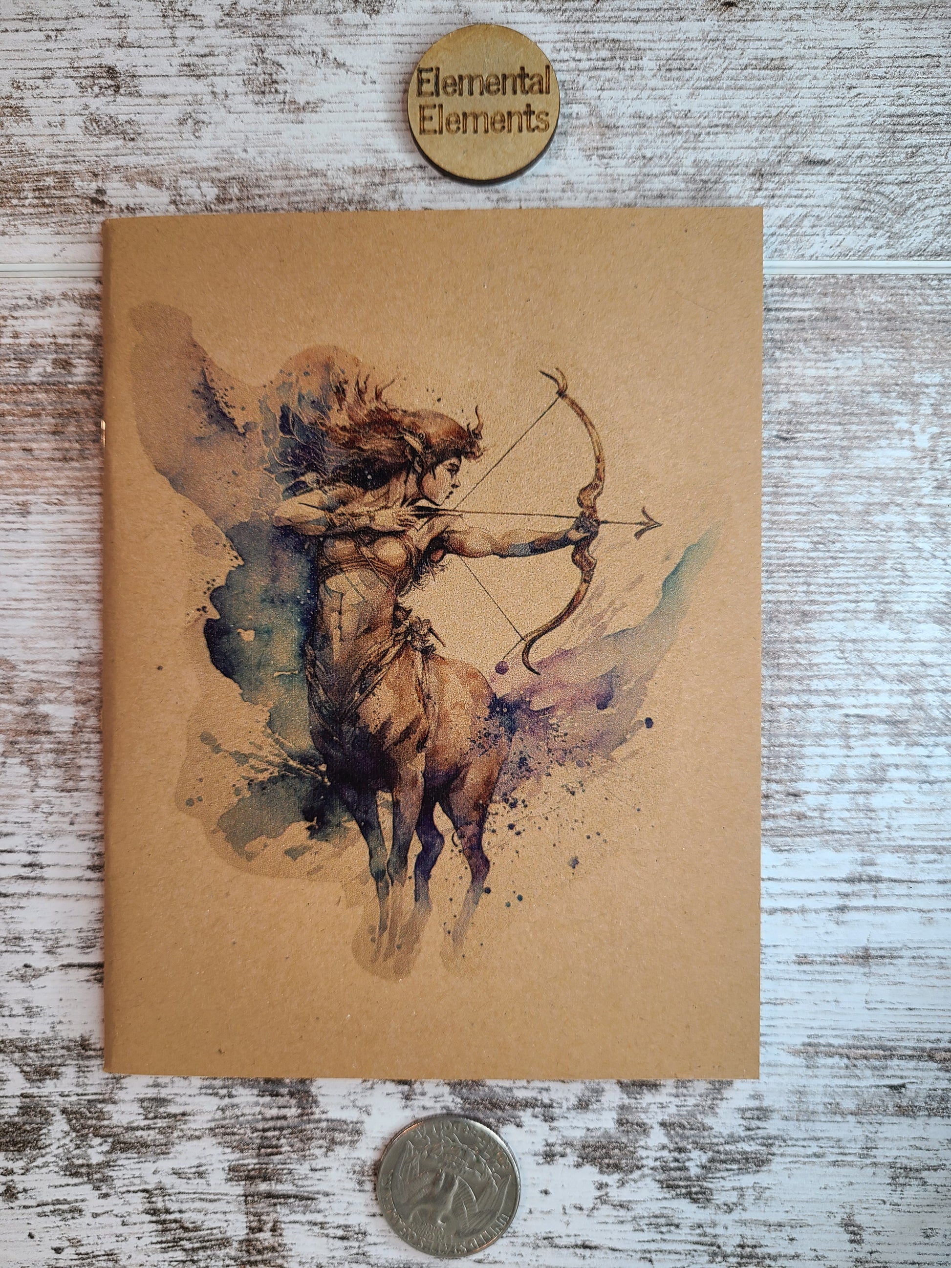 Sagittarius zodiac journal centaur holding a bow and arrow with blue, pink, purple, green, brown, red, and black colors.